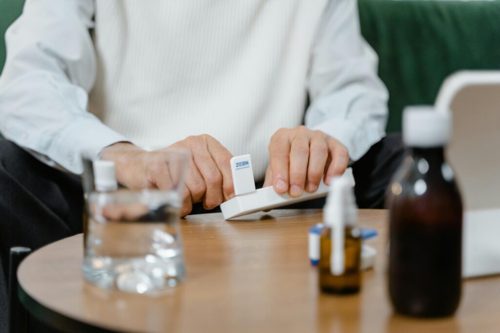 A senior adult preparing medicine doses at home, emphasizing healthcare and telehealth solutions.